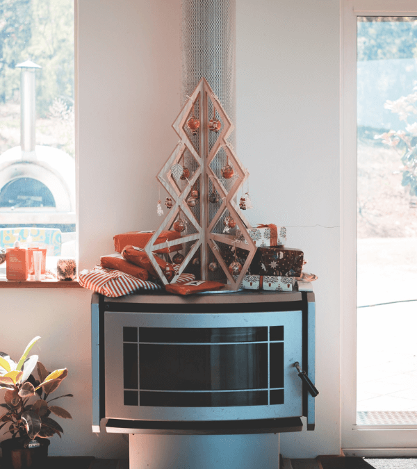 Ein DIY-Weihnachtsbaum aus Holz, geschmückt mit Weihnachtskugeln