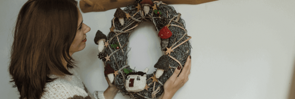 Ein selbstgebastelter Kranz an der Wand, aufgehängt an einem Baumzweig