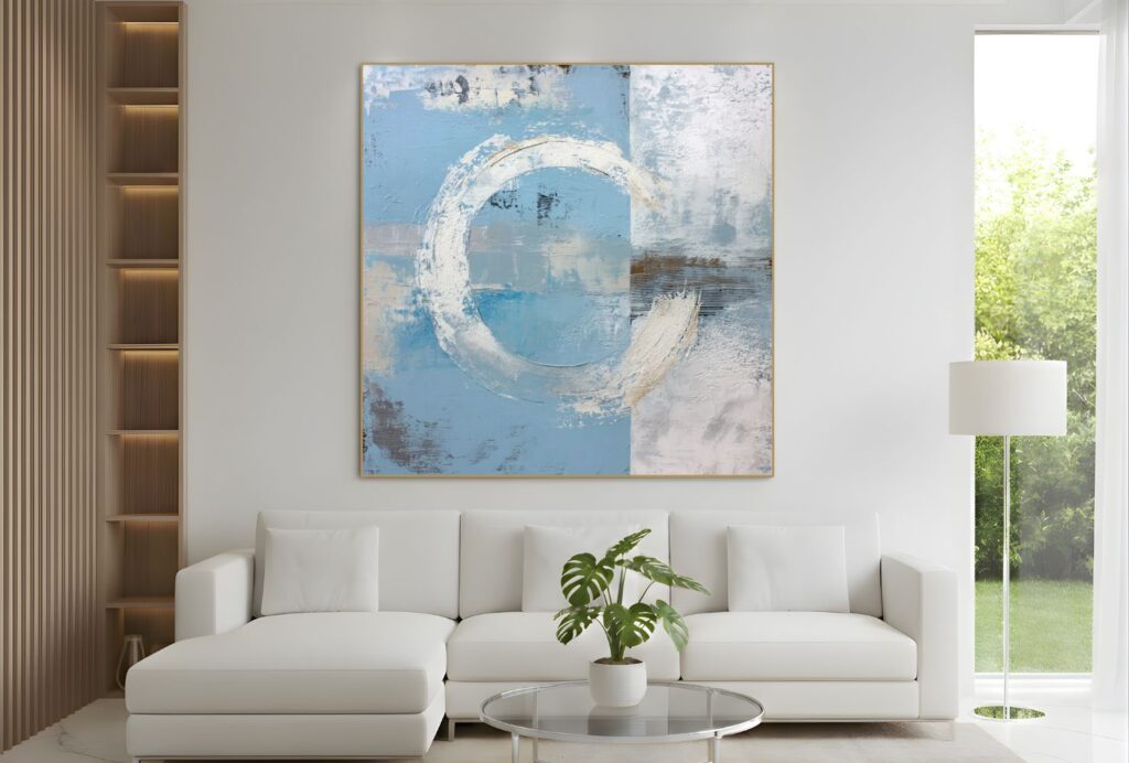 Abstraktes Wandbild mit kreisförmigen Blautönen über einem hellen Sofa in einem modernen Wohnzimmer