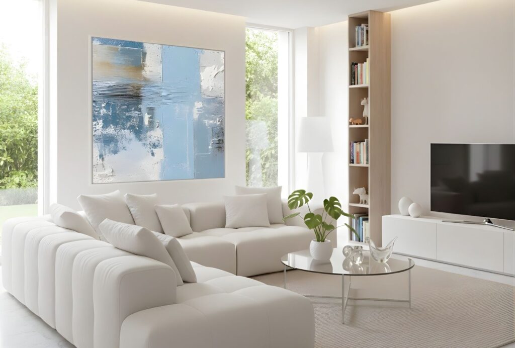 Helles Wohnzimmer mit cremefarbener Couch, minimalistischer Einrichtung und moderner Wandkunst in neutralen Farben