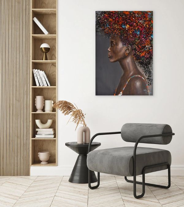 Profile portrait of a woman with colorful abstract flowers in her hair, hanging in a bright Scandi-style room next to a wooden bookshelf and modern grey armchair.